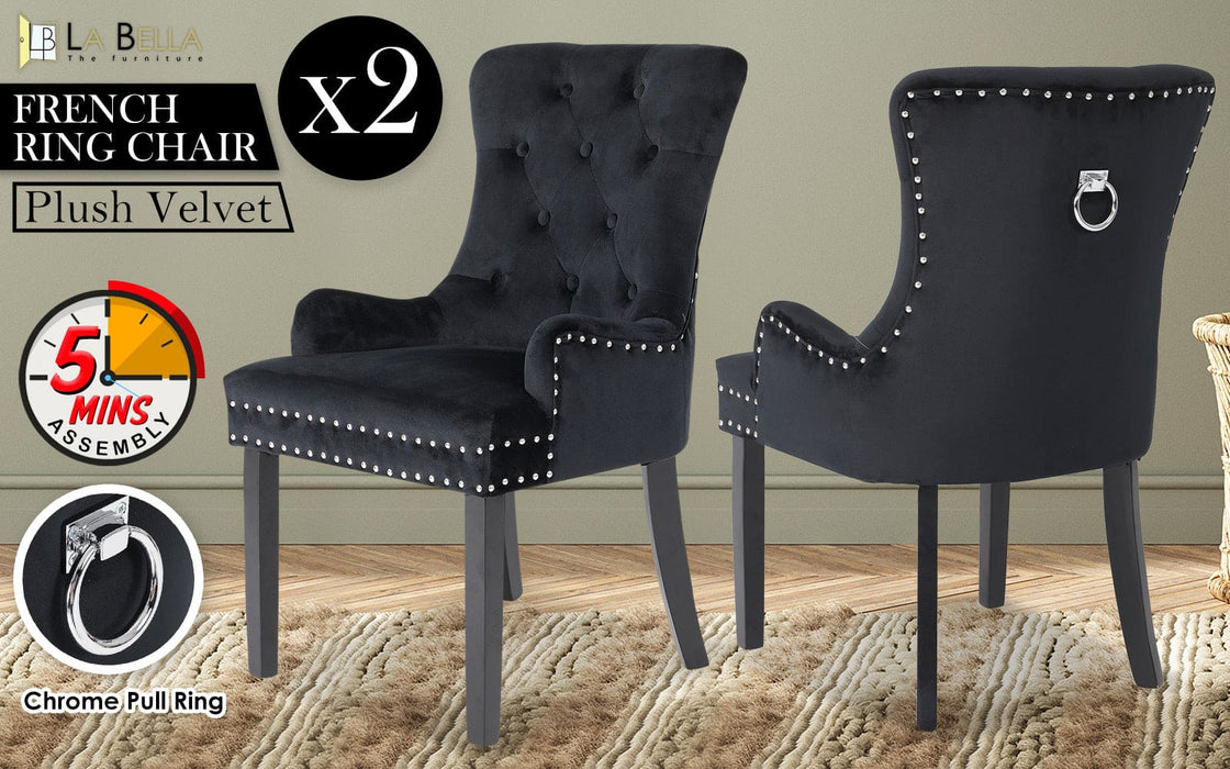 Front and back view of the La Bella Velvet Black French Provincial Dining Chair set in and indoor setting resting on a carpet on top of a timber floor, in front of a grey wall.