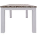 End view of The Plumeria Solid Acacia Wood Dining Table with a White Background